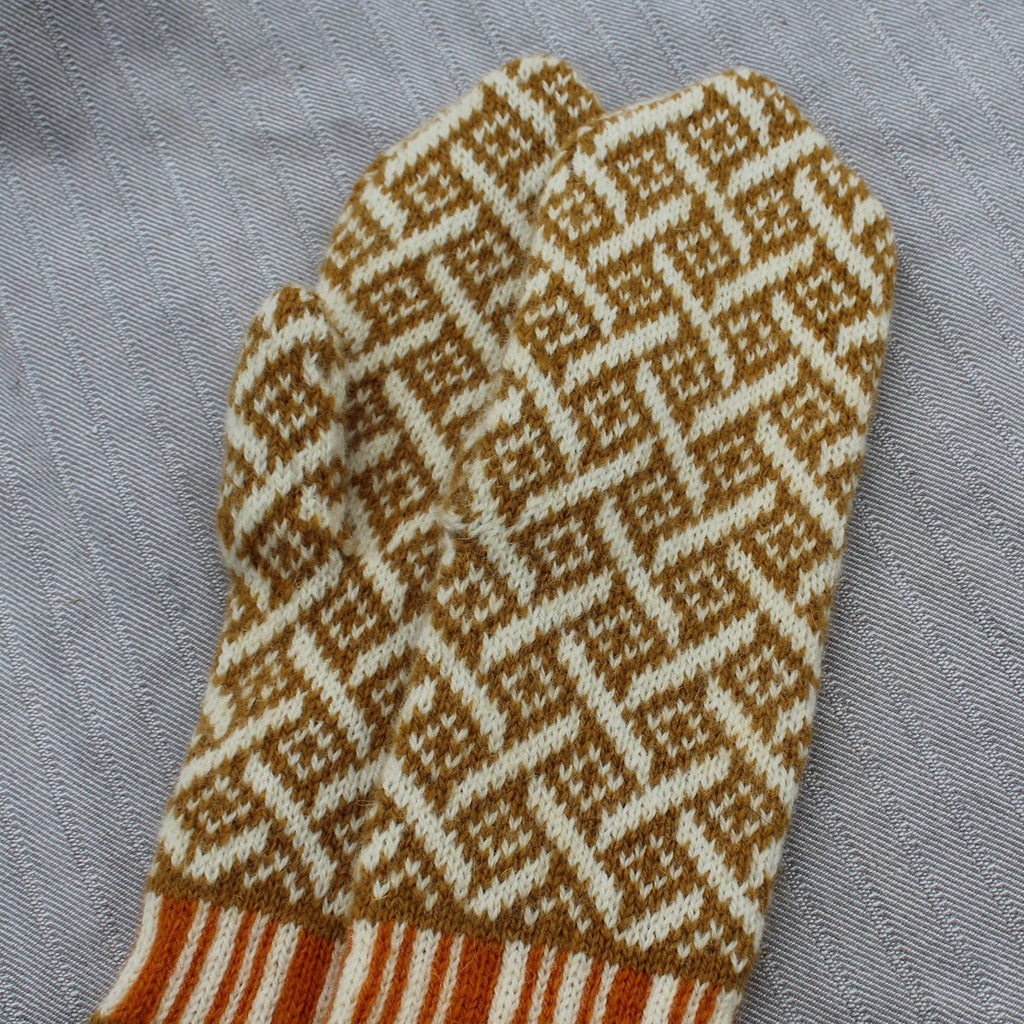 Knitted mittens with a geometric pattern on a gray fabric background