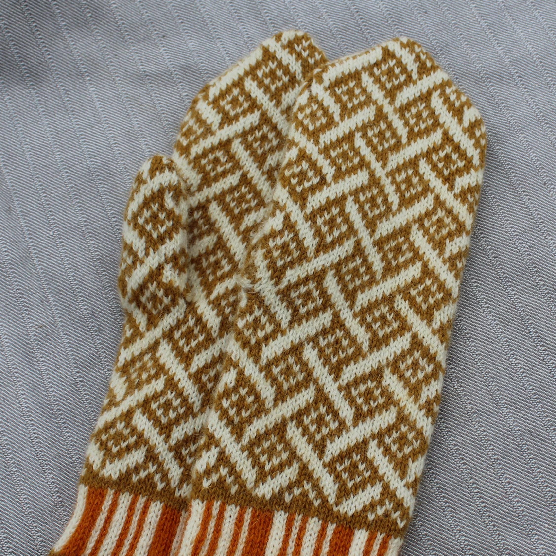 Knitted mittens with a geometric pattern on a gray fabric background