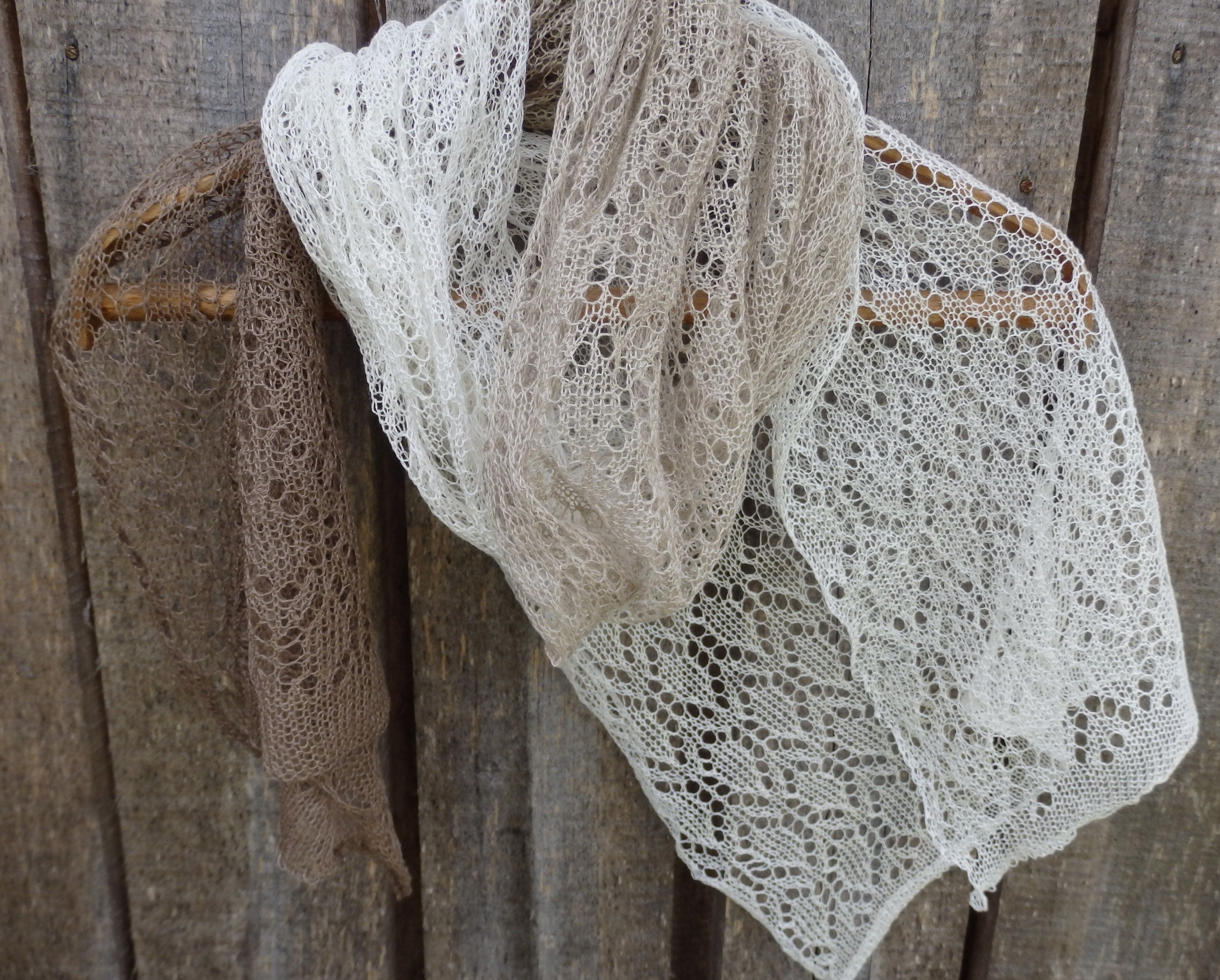 Delicate lace shawl draped over a wooden surface