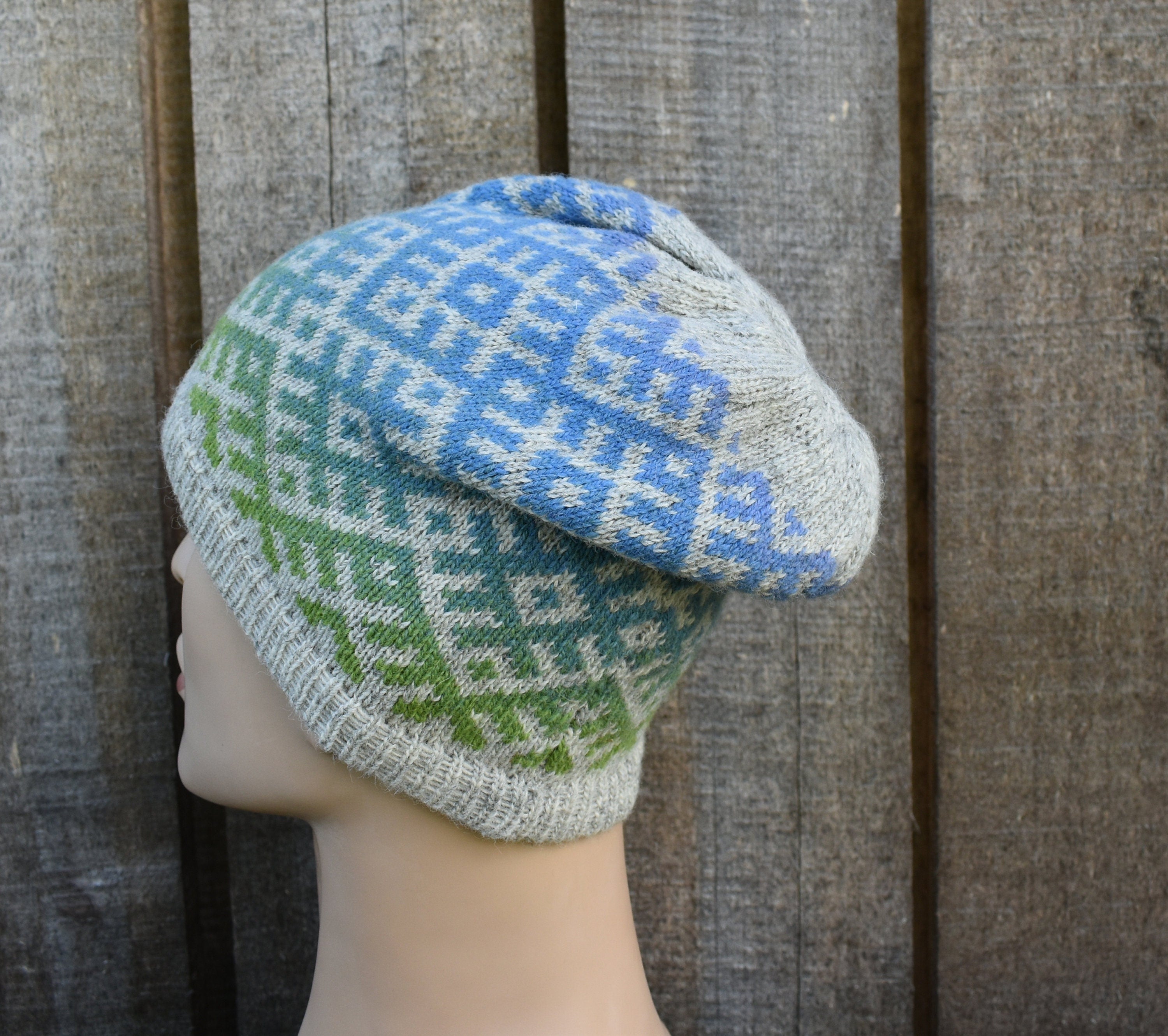 Knitted hat with geometric pattern on a mannequin head against a wooden background