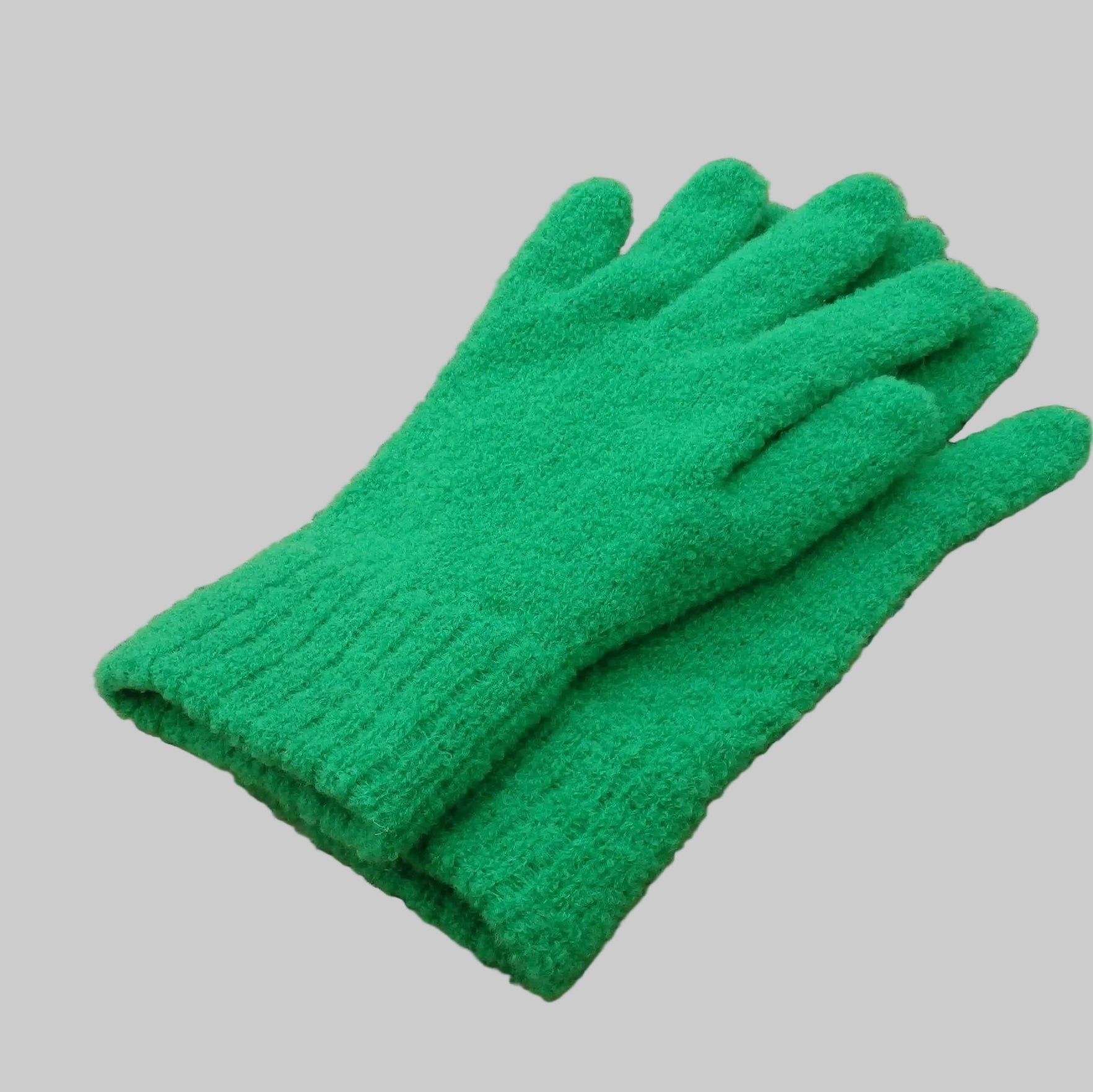 Green  merino gloves on a woven mat
