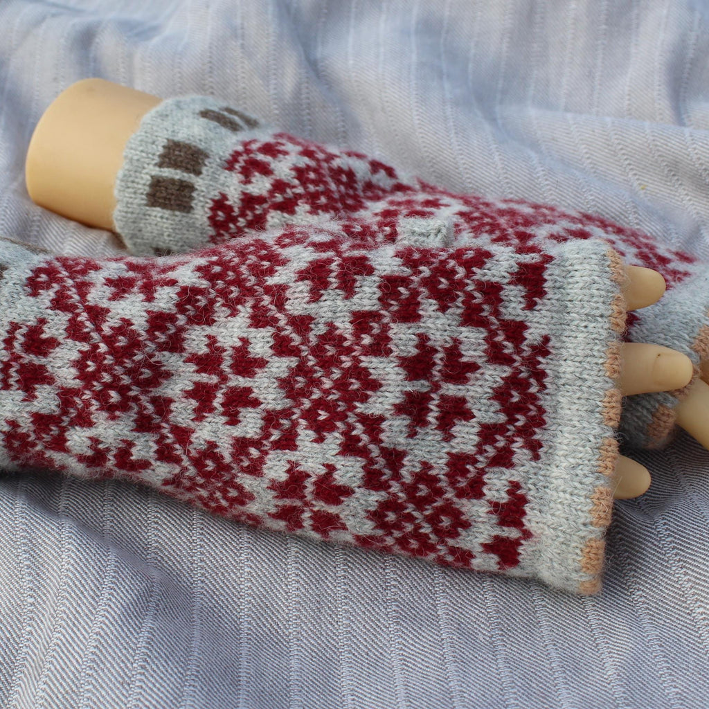 Knitted gloves with a red and white pattern on a fabric background
