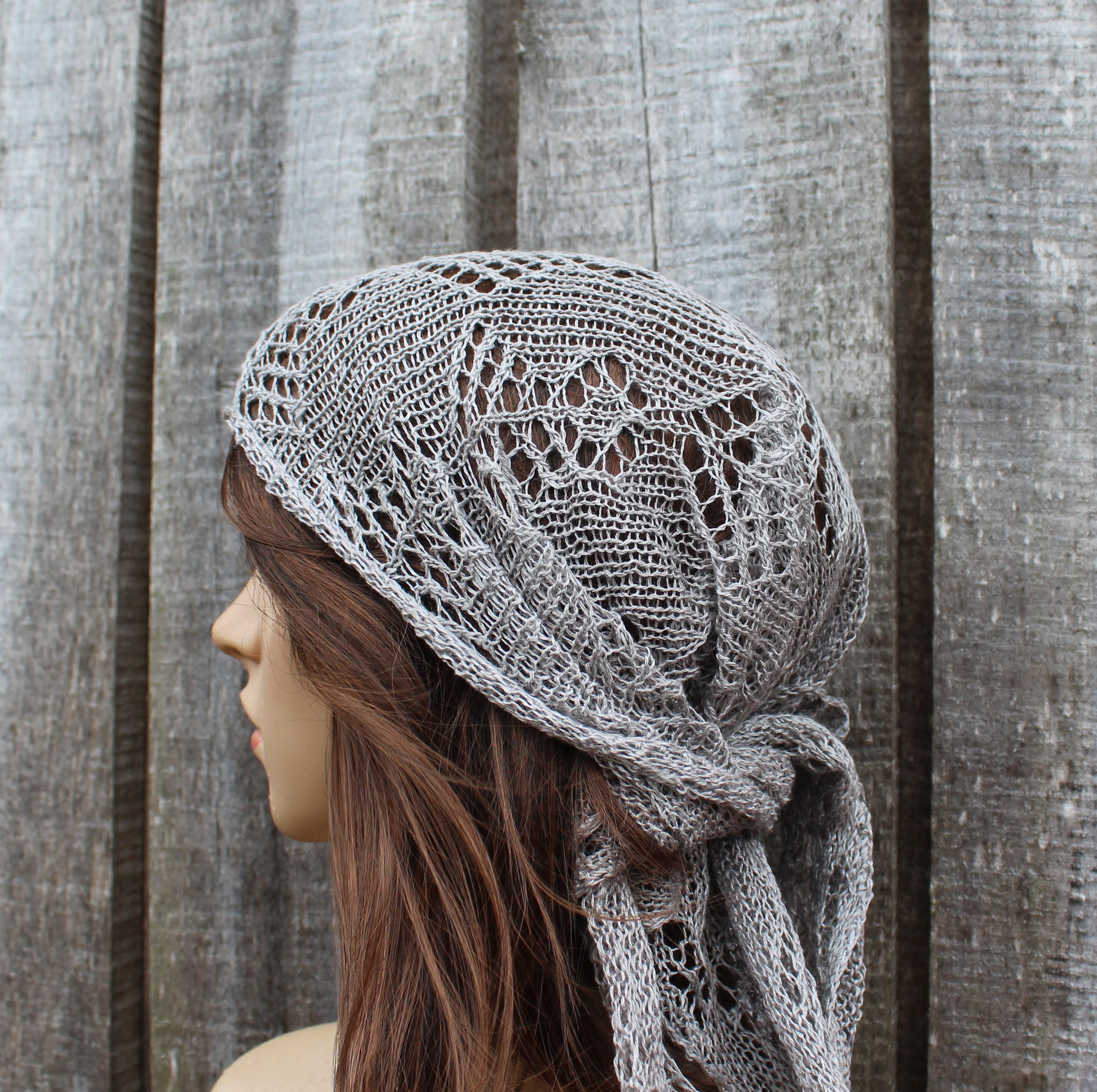 Woman wearing a gray knitted headscarf against a wooden background