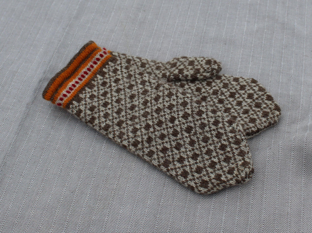 Pair of patterned mittens on a textured fabric background