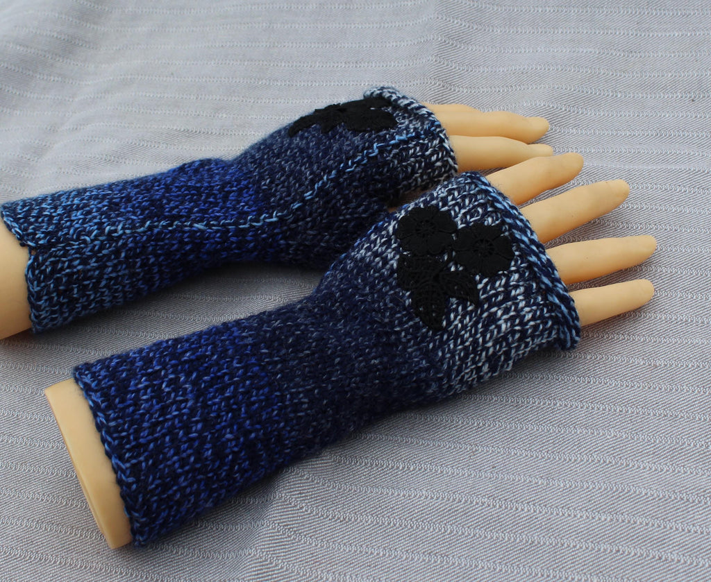 Blue knitted fingerless gloves on a gray fabric background