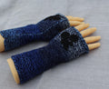 Blue knitted fingerless gloves on a gray fabric background