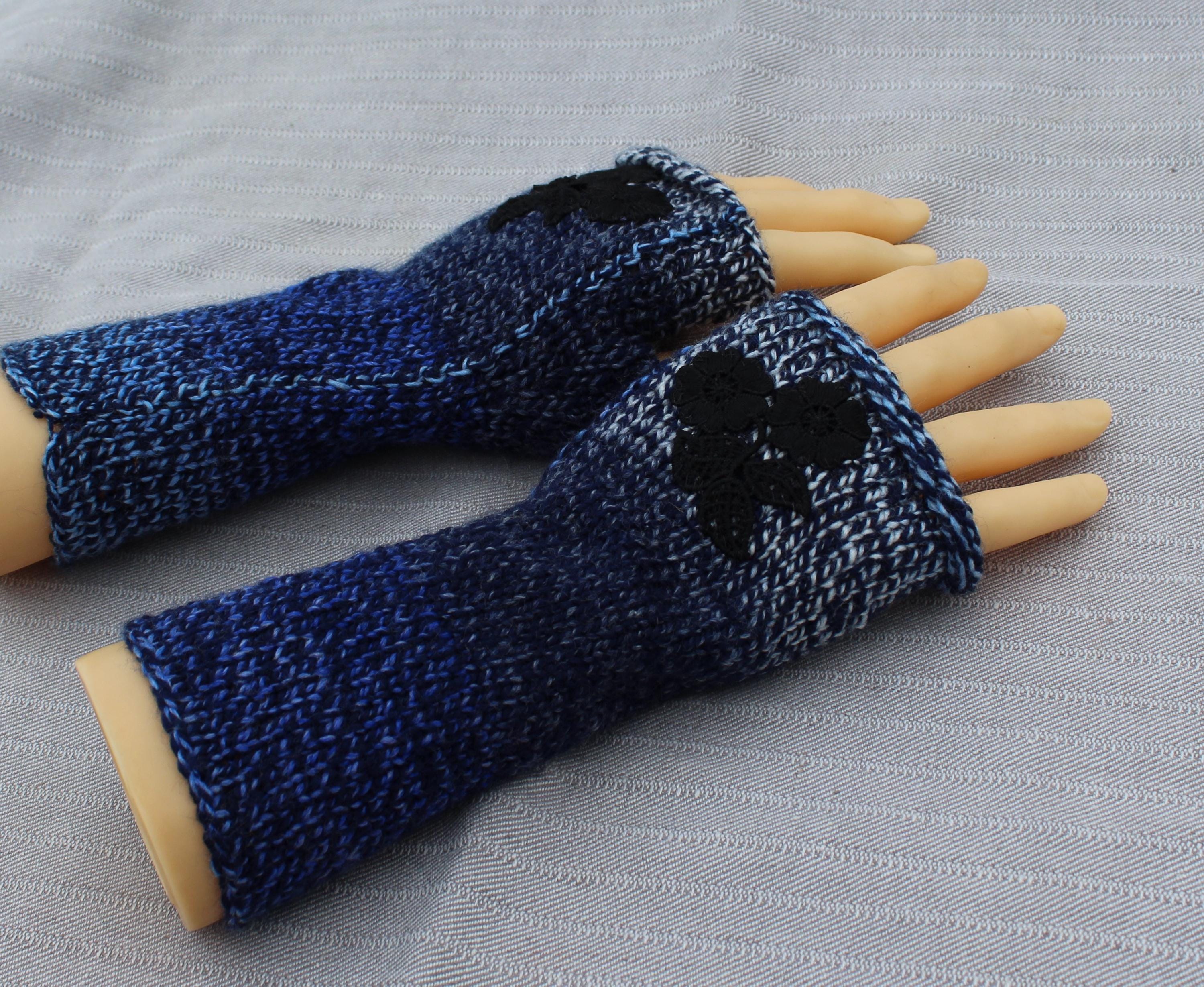 Blue knitted fingerless gloves on a gray fabric background
