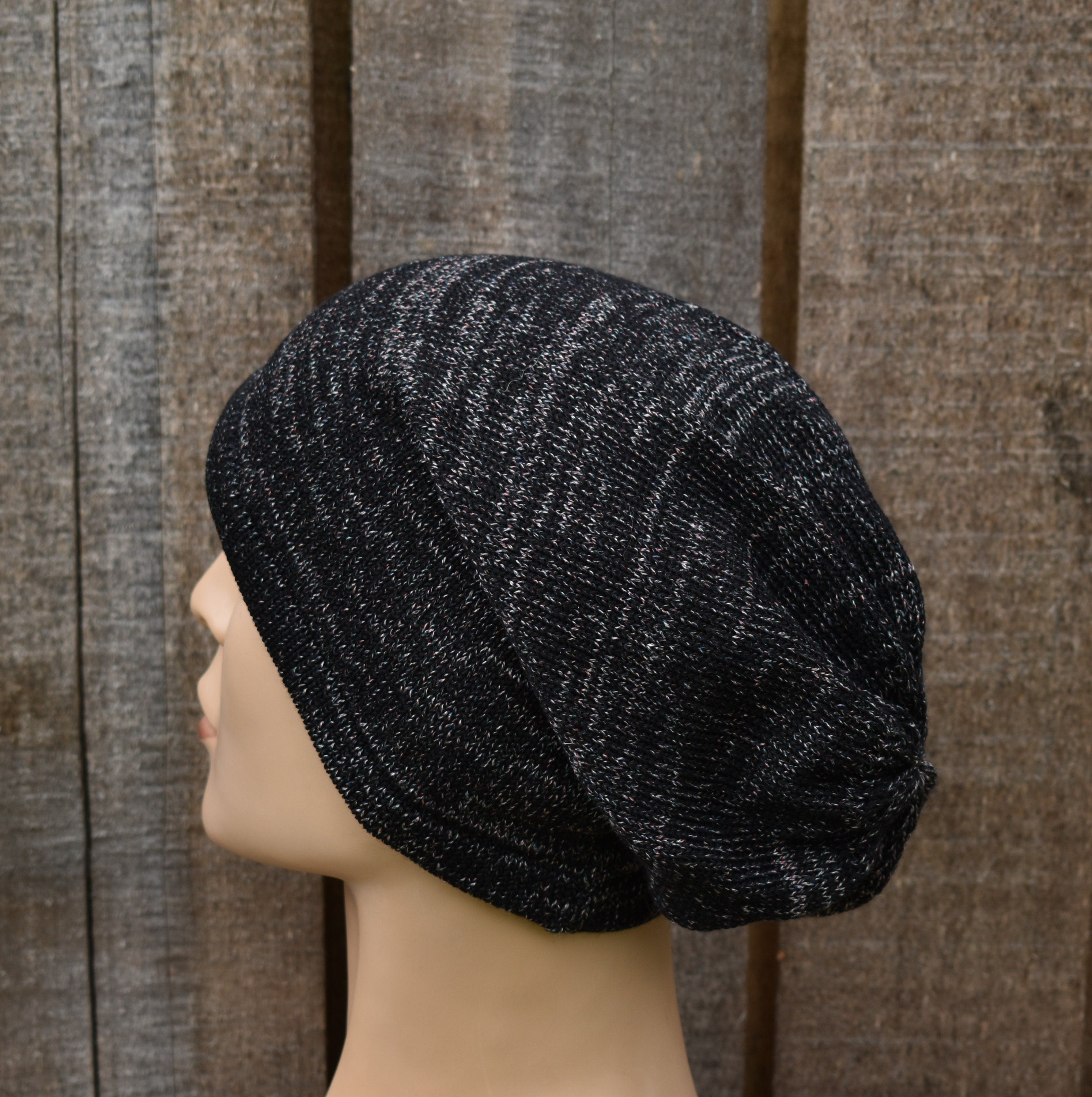 Black textured beanie on a mannequin head against a wooden panel background
