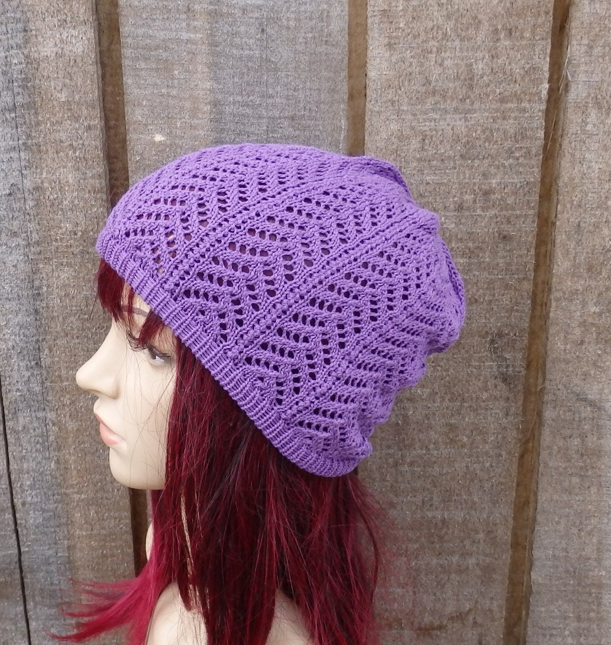 Person wearing a purple knitted hat against a wooden background