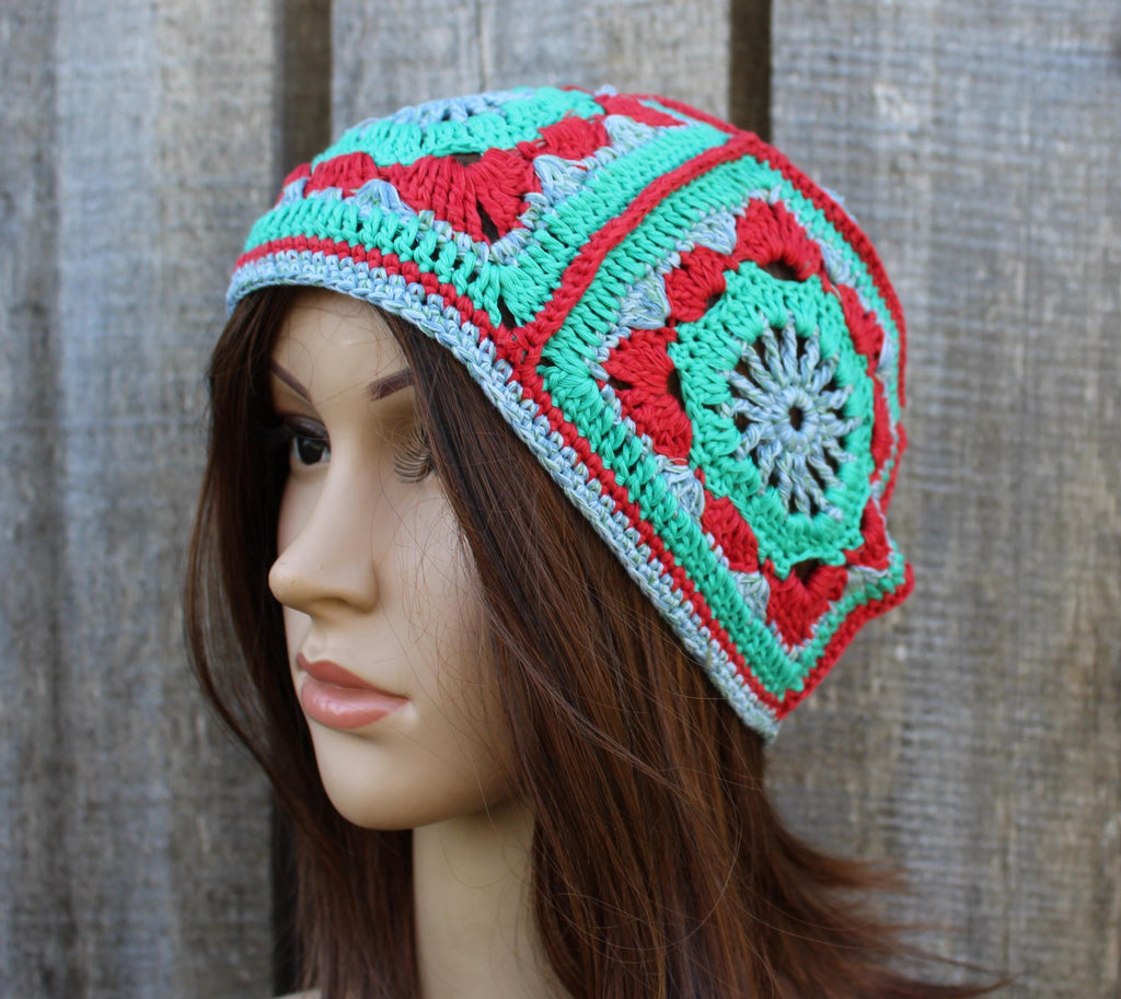 Colorful crocheted beanie on a mannequin head against a wooden background