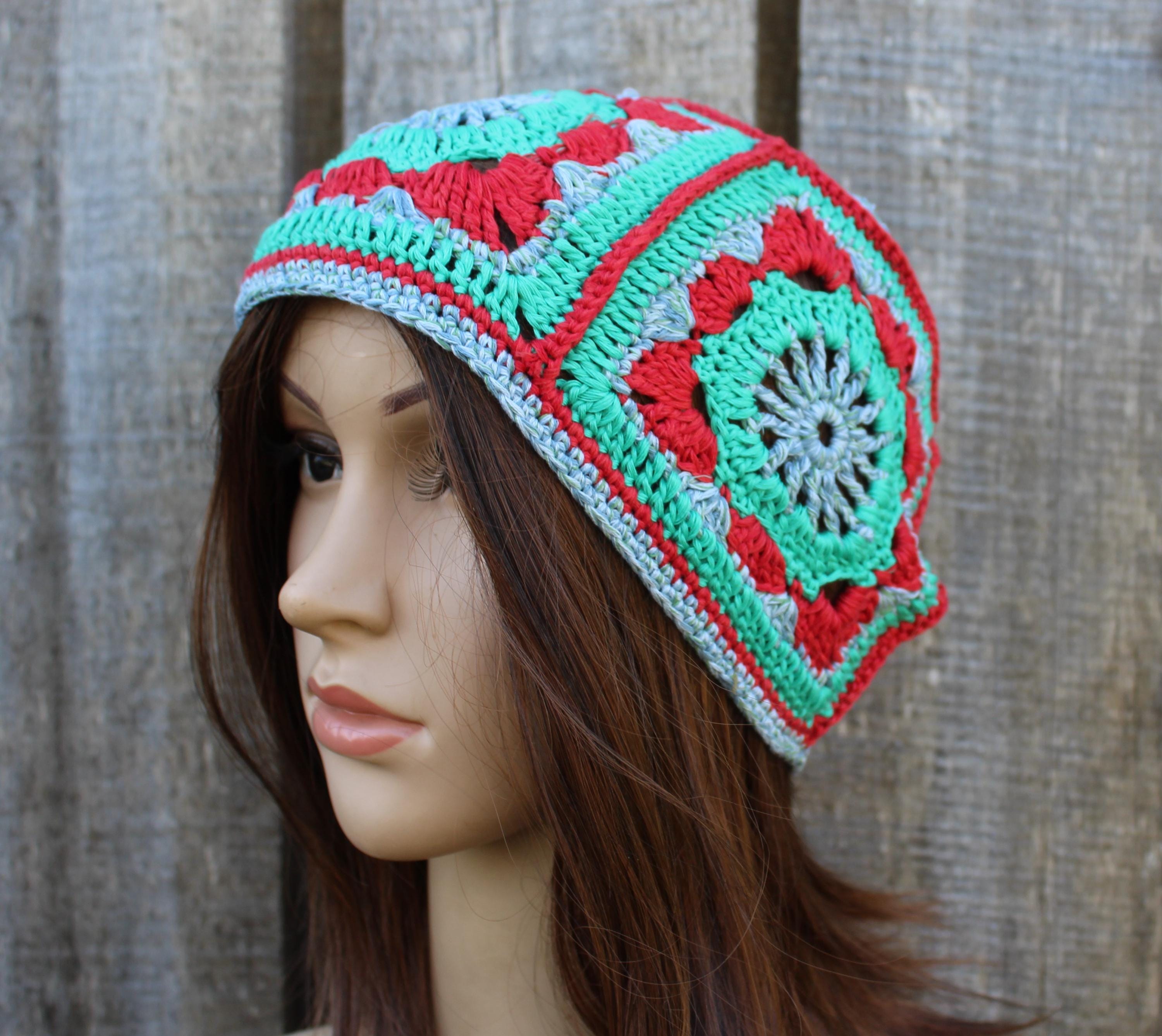 Colorful crocheted beanie on a mannequin head against a wooden background