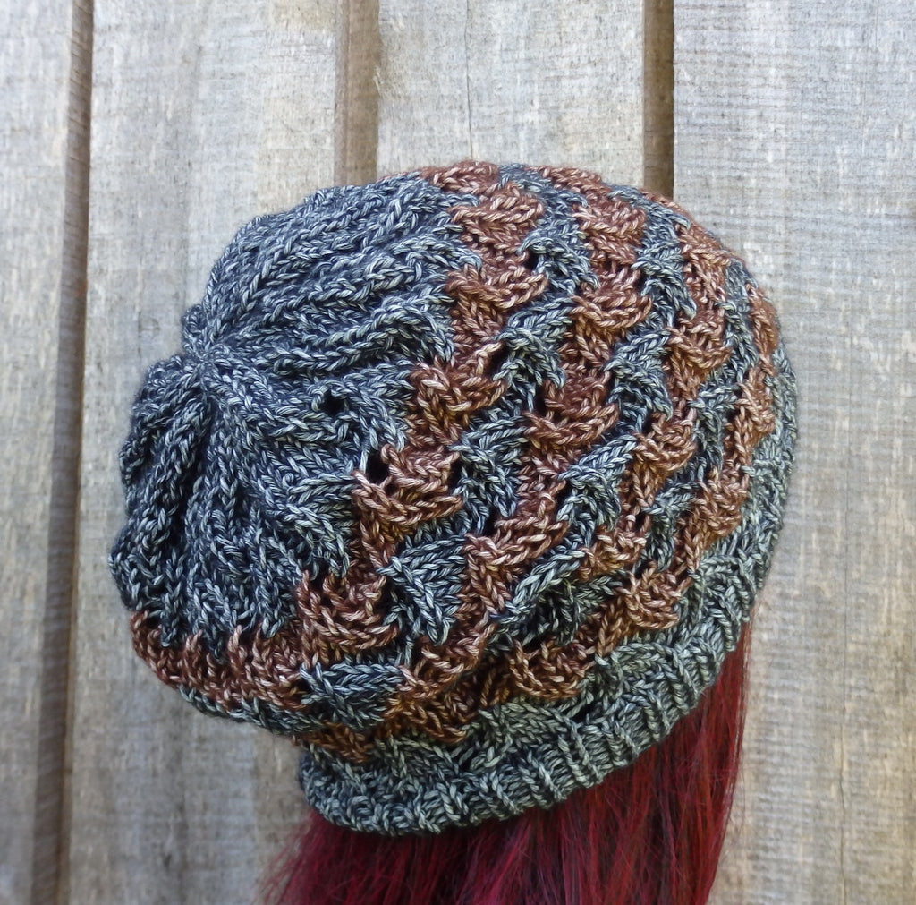 Knitted beanie with a gradient pattern on a wooden surface