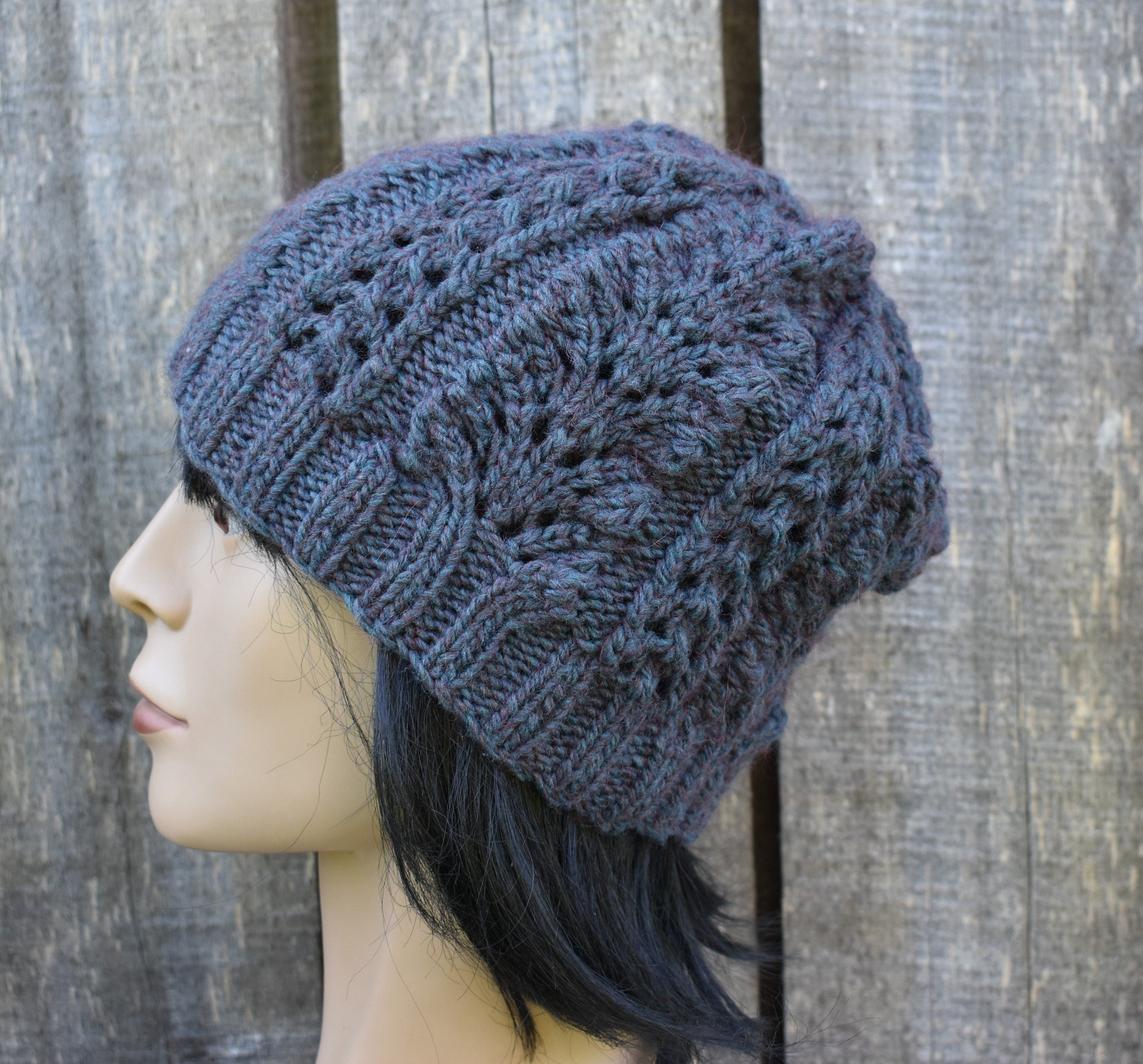 Knitted hat on a mannequin head against a wooden background