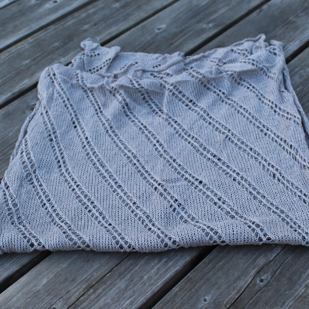 Folded gray knitted garment on a wooden surface