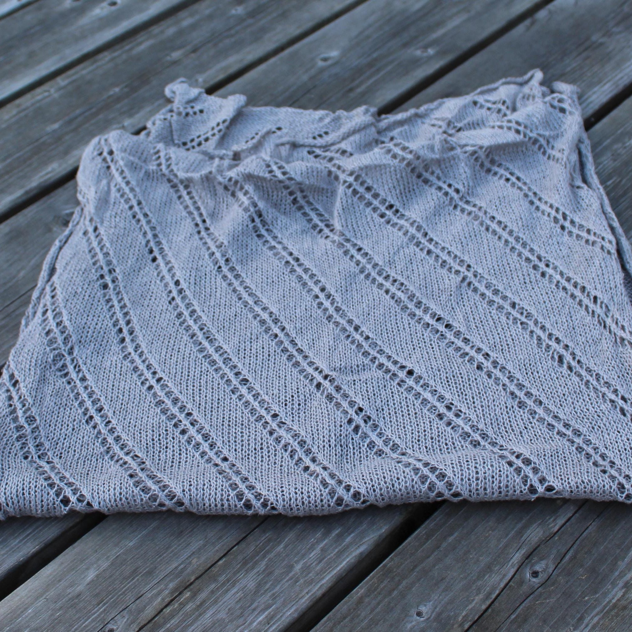 Folded gray knitted garment on a wooden surface