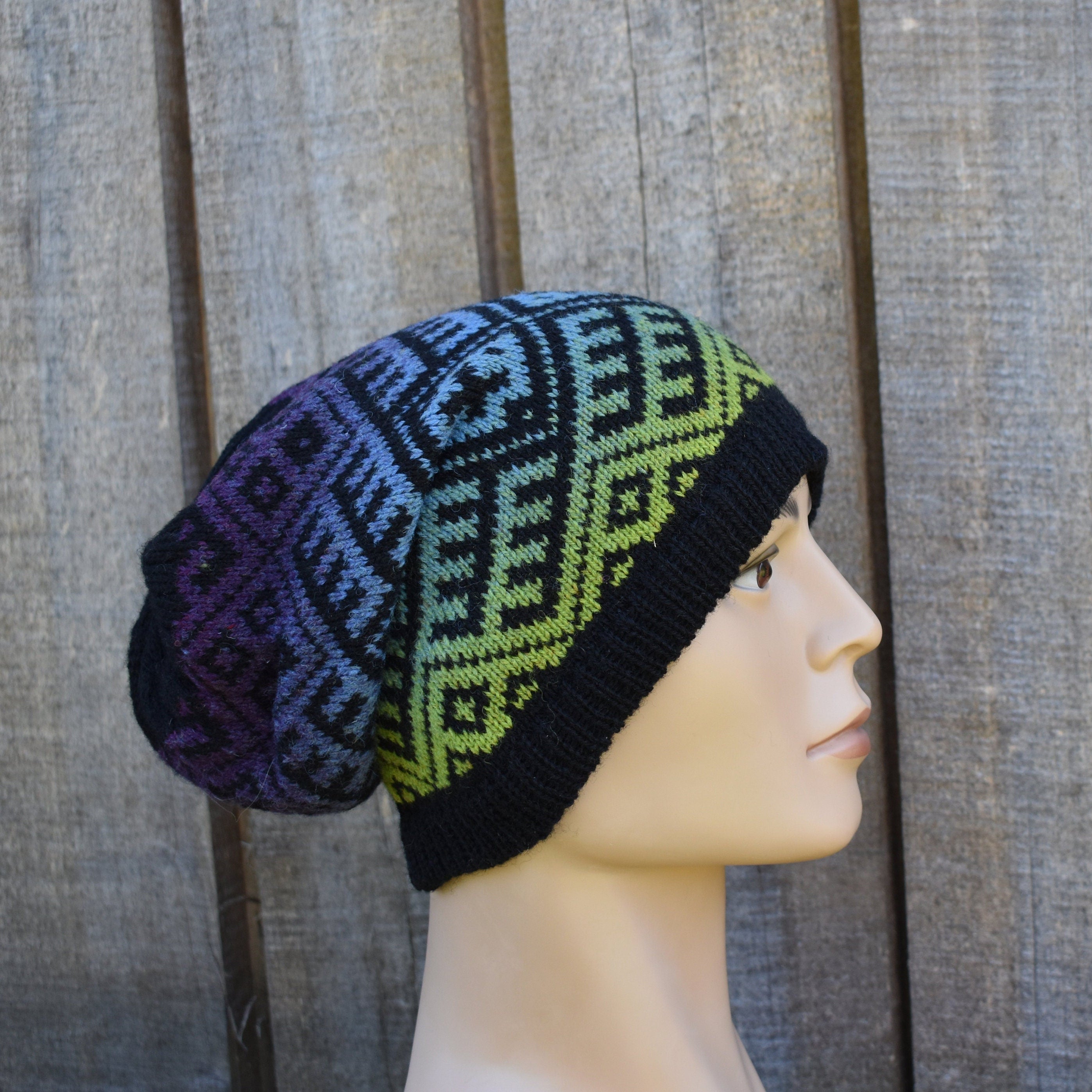 Knitted beanie with a geometric pattern on a mannequin head against a wooden background