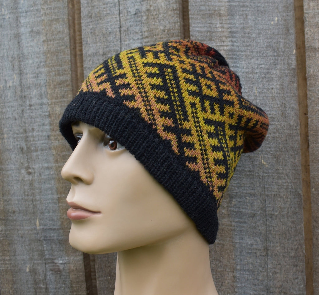 Knitted beanie with a geometric pattern on a mannequin head against a wooden background