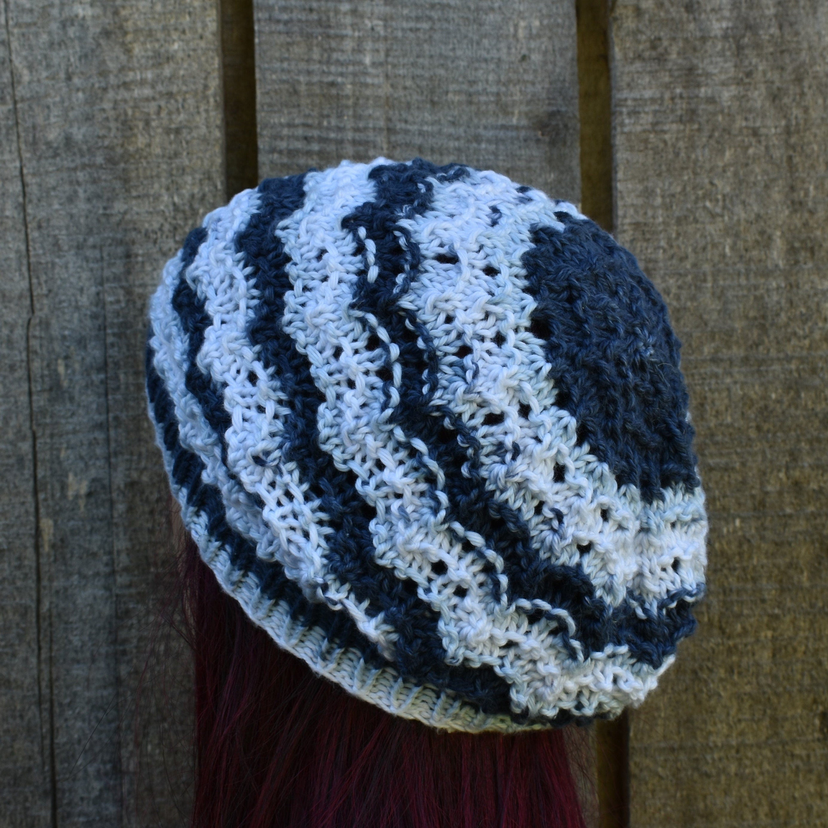 Knitted beanie with blue and white pattern against a wooden background