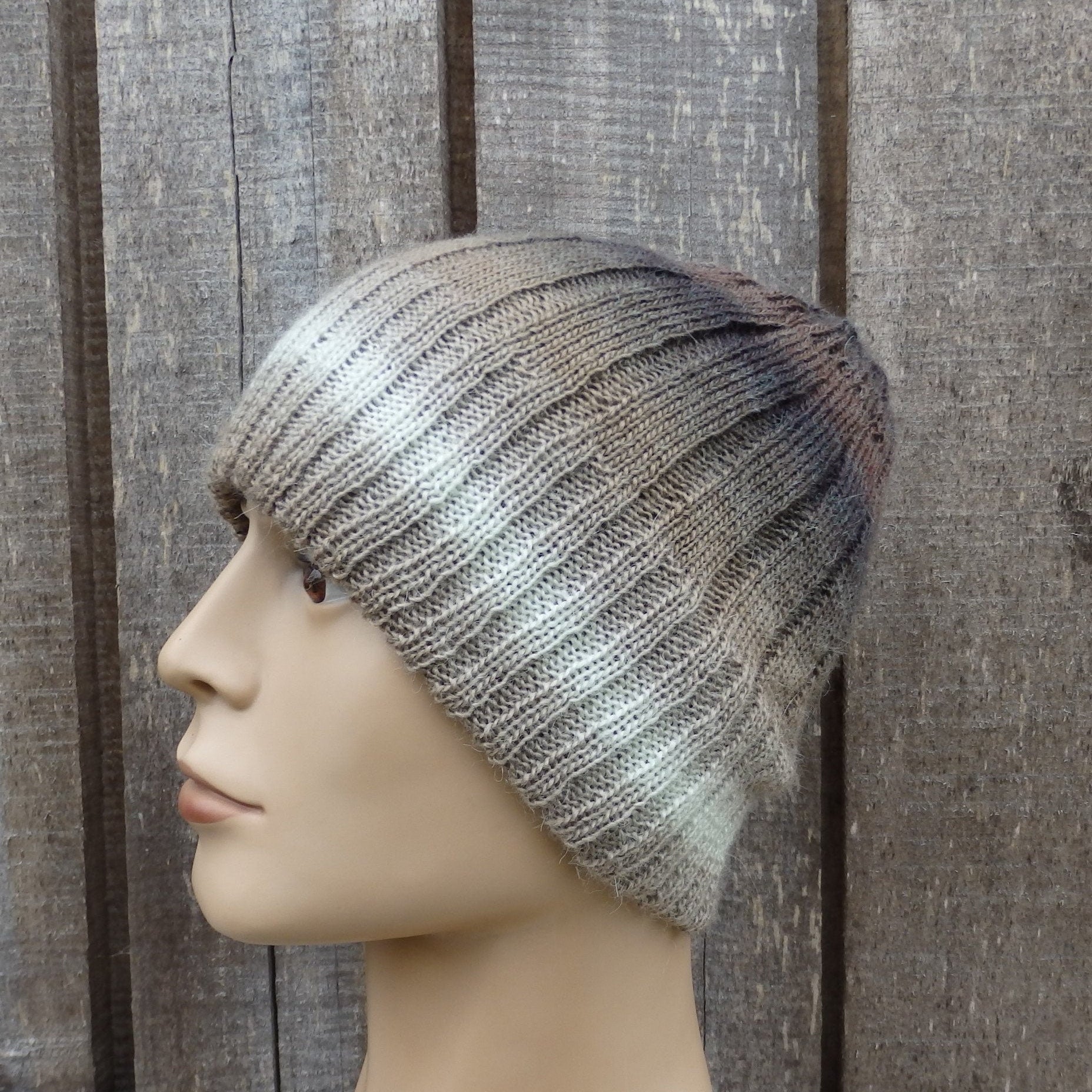 Knitted beanie on a mannequin head against a wooden background