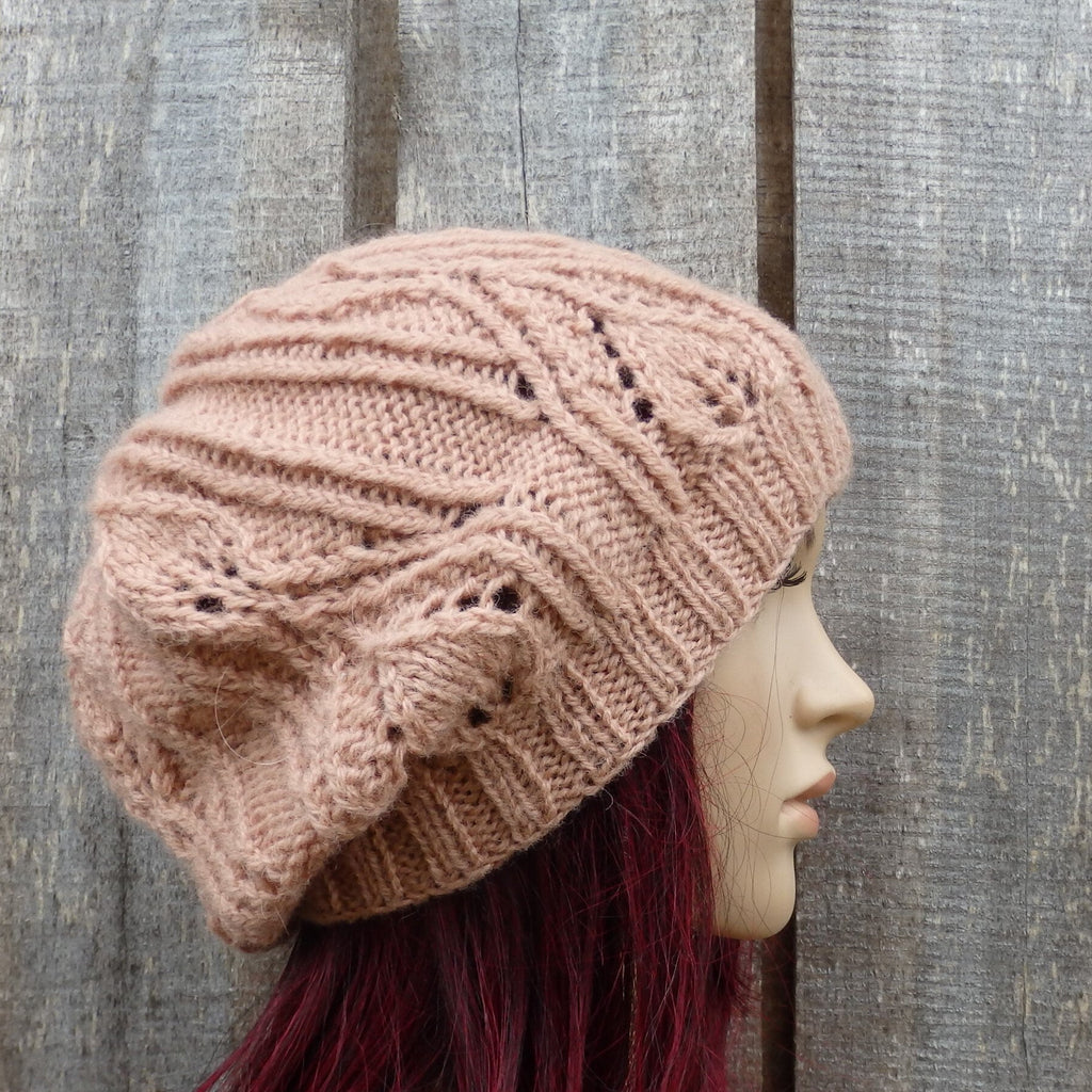 Knitted pink beanie on a mannequin head against a wooden background