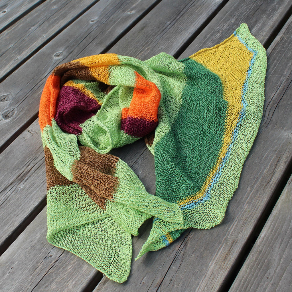 Colorful knitted shawl on a wooden surface