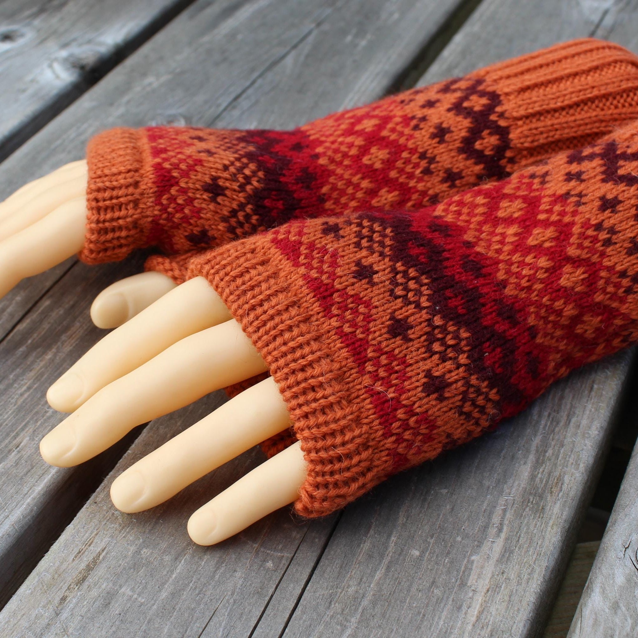 Knitted gloves with a pattern on a wooden surface