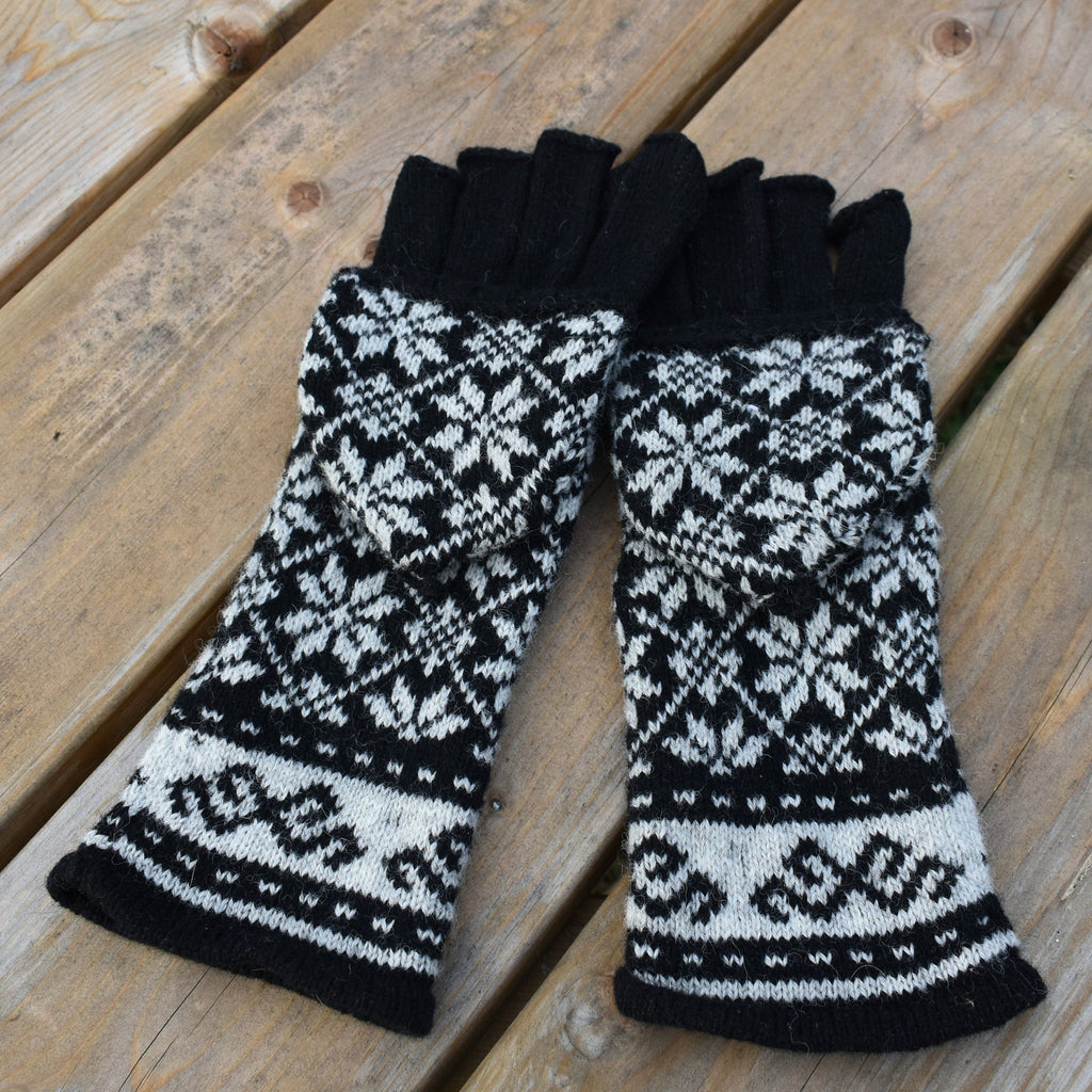 Pair of black and white patterned gloves on a wooden surface