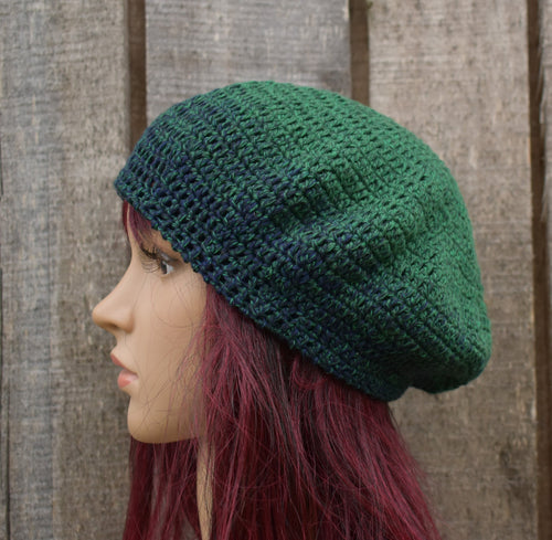 Green knitted beanie on a mannequin head against a wooden background