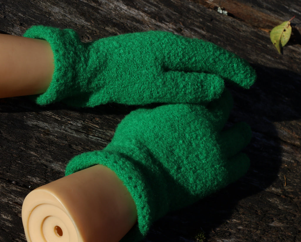 Green gardening gloves on a wooden surface