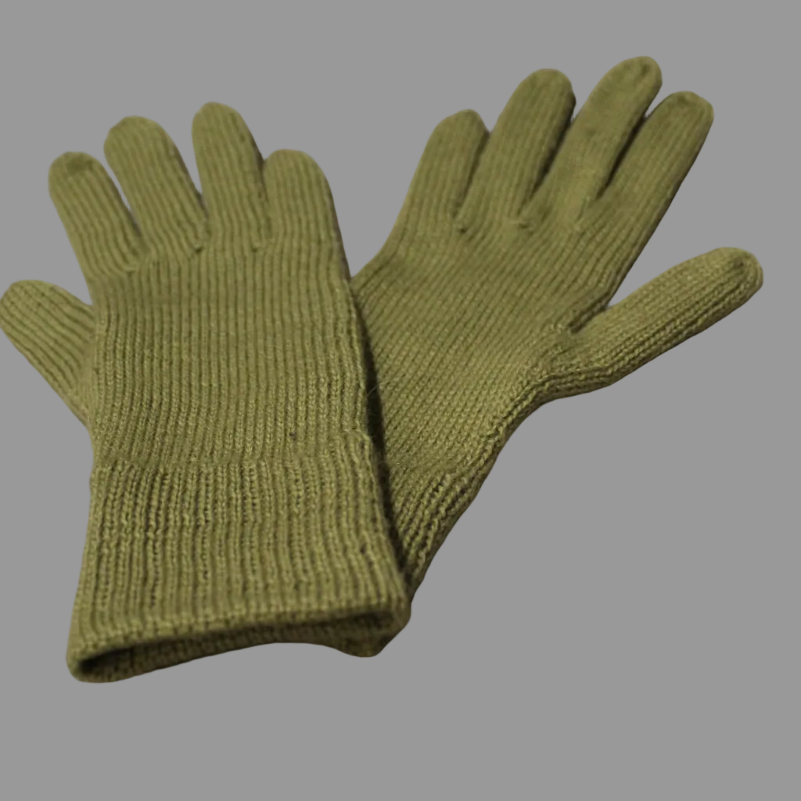 Pair of green gloves on a light gray surface