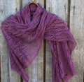 Purple knitted shawl draped over a wooden surface