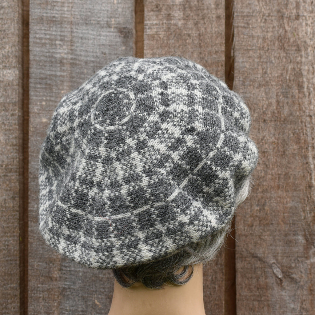 Textured knit cap worn by a person against a wooden background