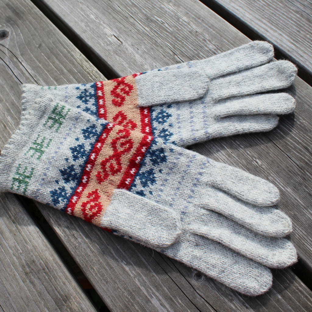 Pair of gray gloves with colorful pattern on a wooden surface