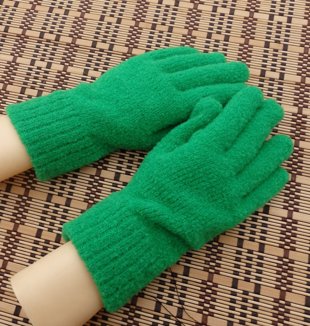 Green gloves worn on a hand against a woven mat background