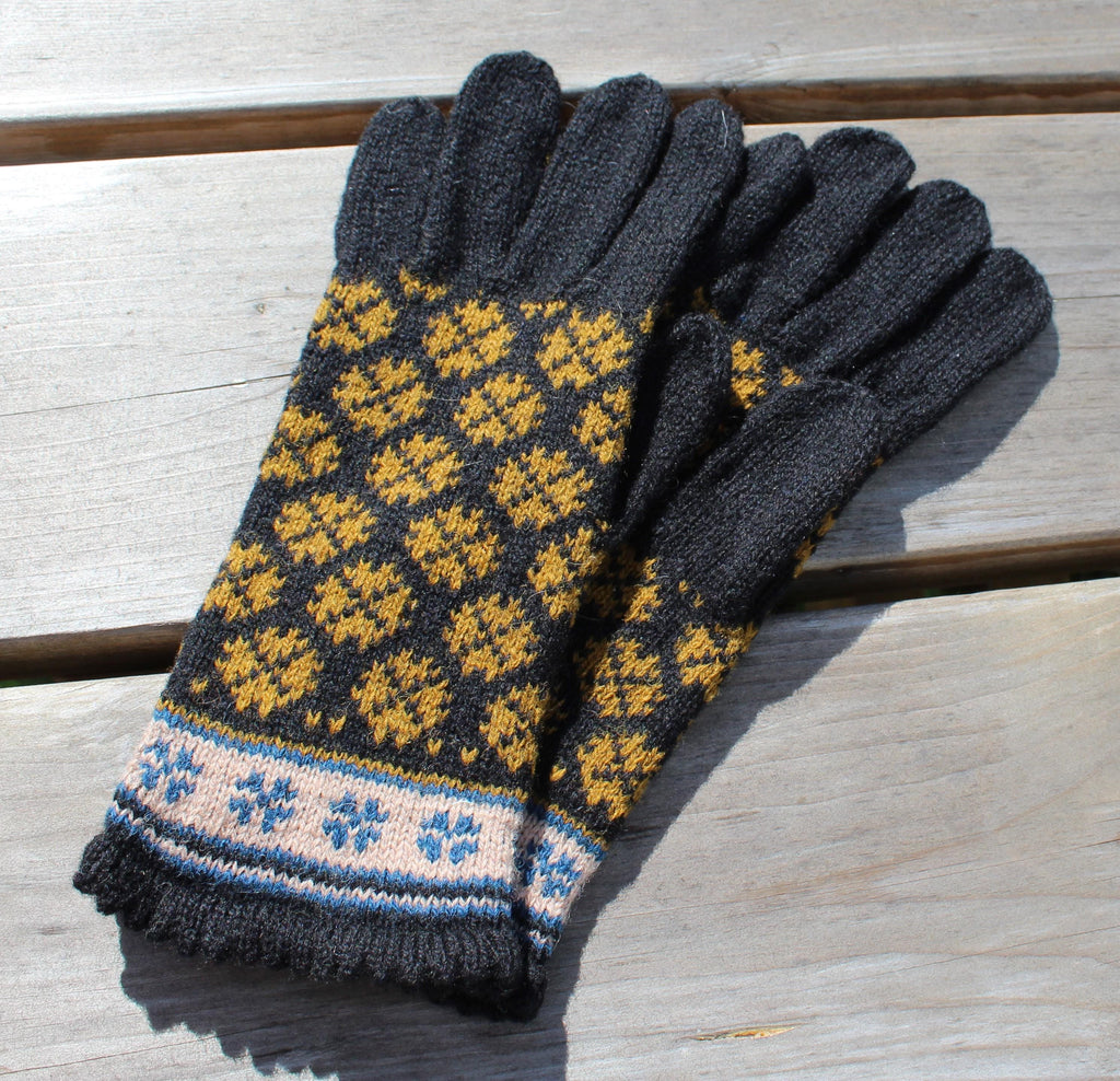 Pair of dark gray gloves with a geometric pattern on a wooden surface