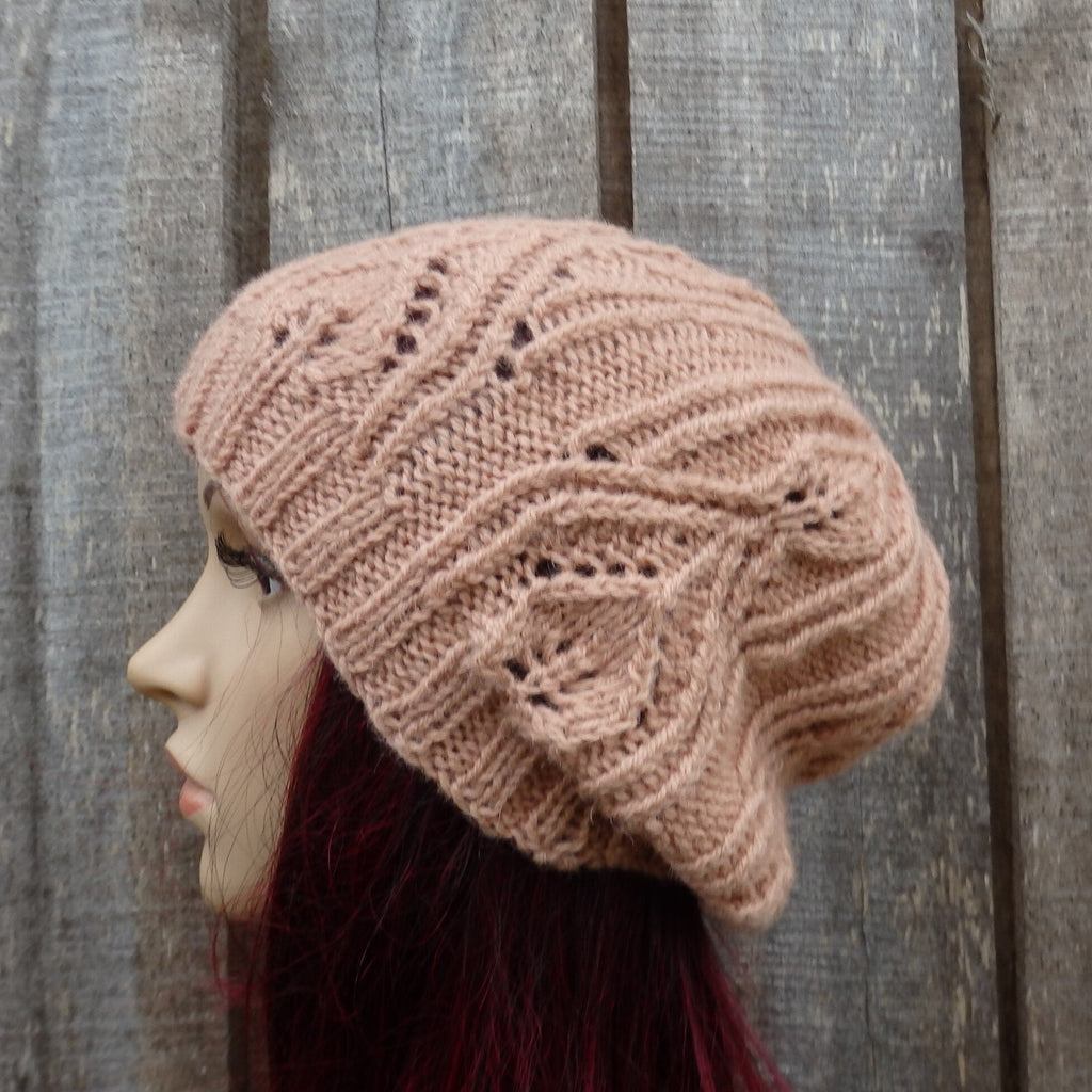 Knitted beige beanie on a mannequin head against a wooden background