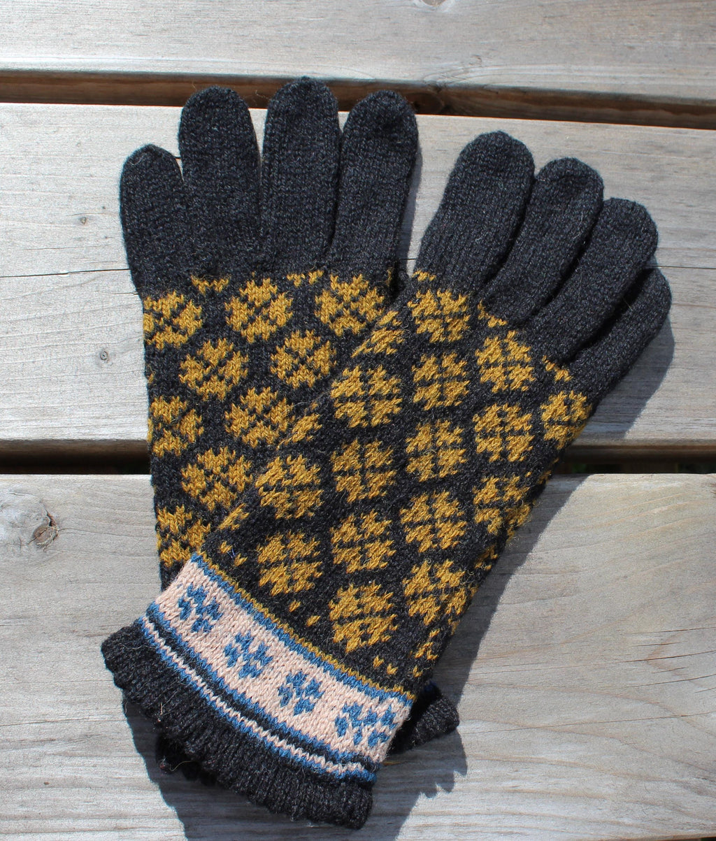 Pair of gloves with a black and yellow pattern on a wooden surface