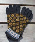 Pair of gloves with a black and yellow pattern on a wooden surface