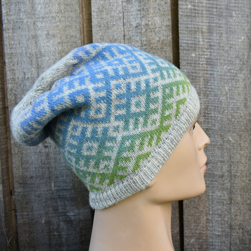 Knitted hat with a geometric pattern on a mannequin head against a wooden background