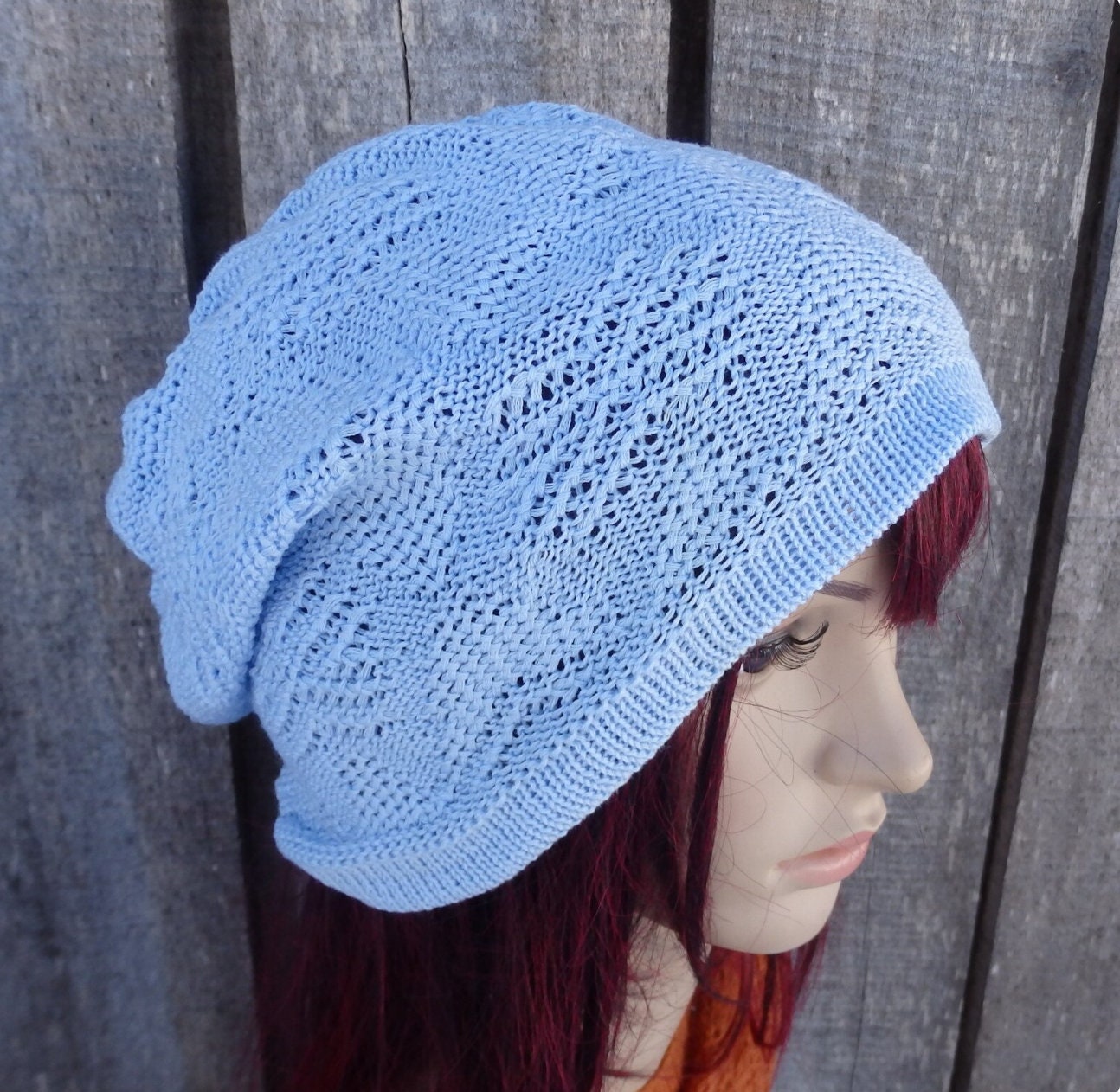 Light blue knitted beanie on a mannequin head against a wooden background