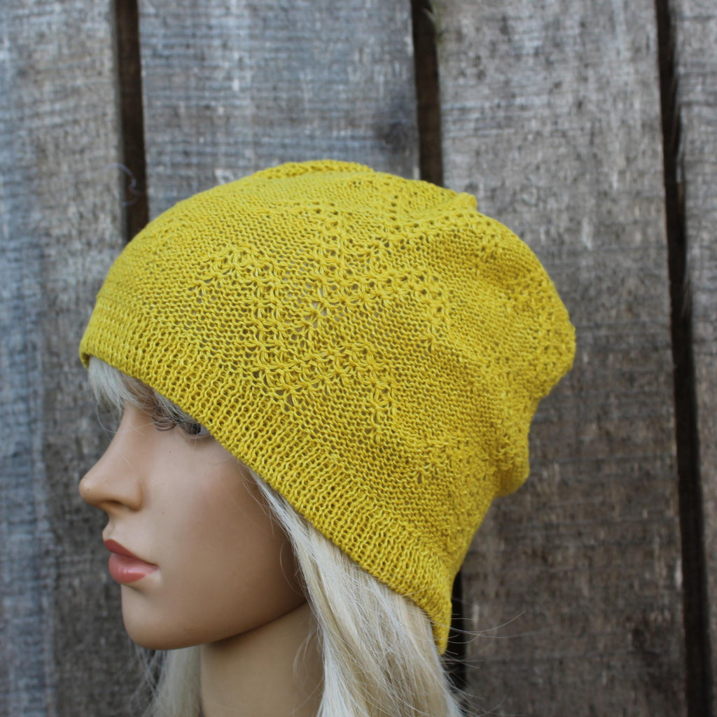 Yellow knitted beanie on a mannequin head against a wooden background