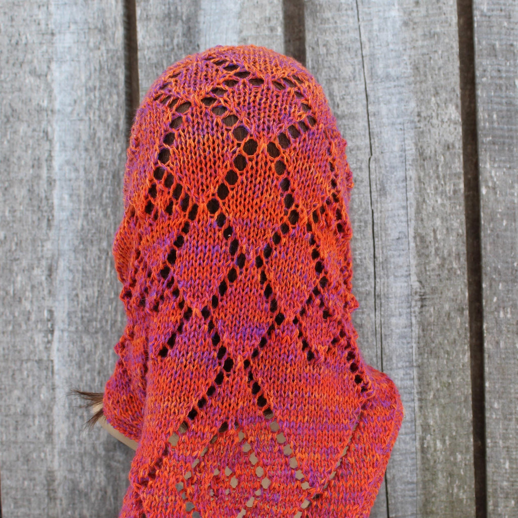 Knitted head dress with a geometric pattern on a wooden background