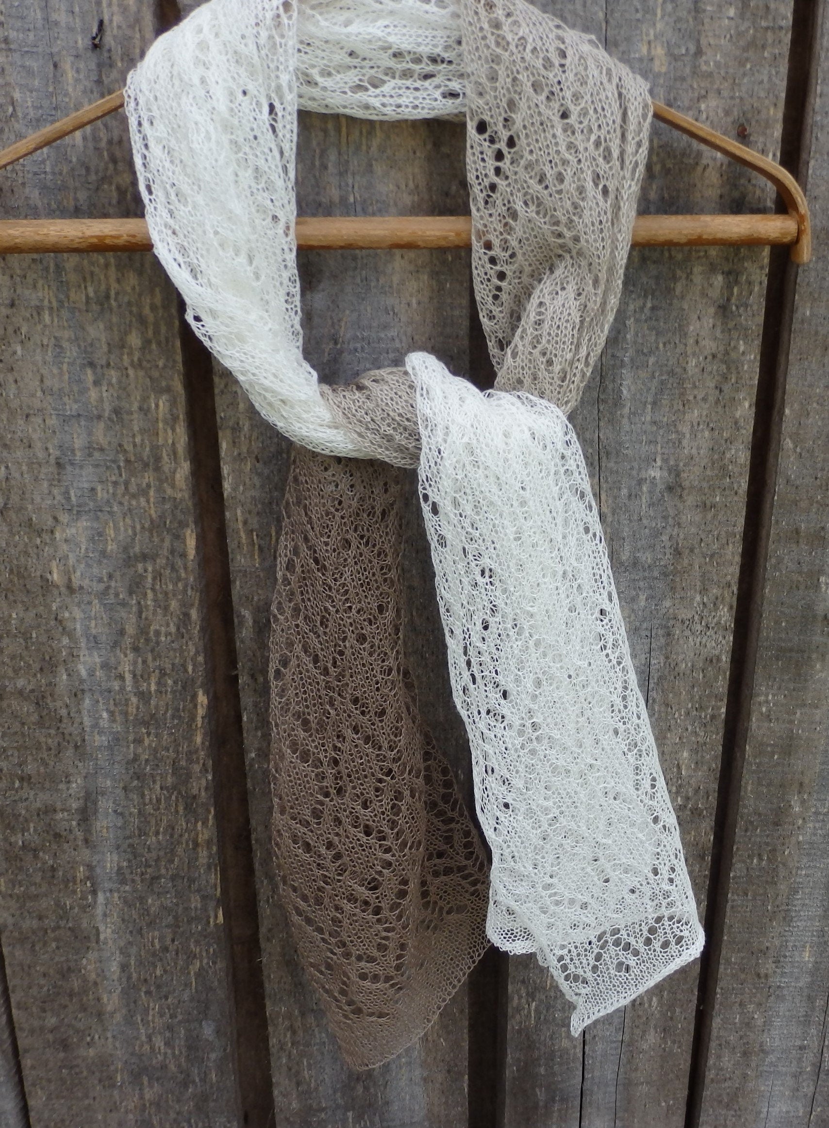 Lace scarf draped over a wooden hanger against a rustic wooden background