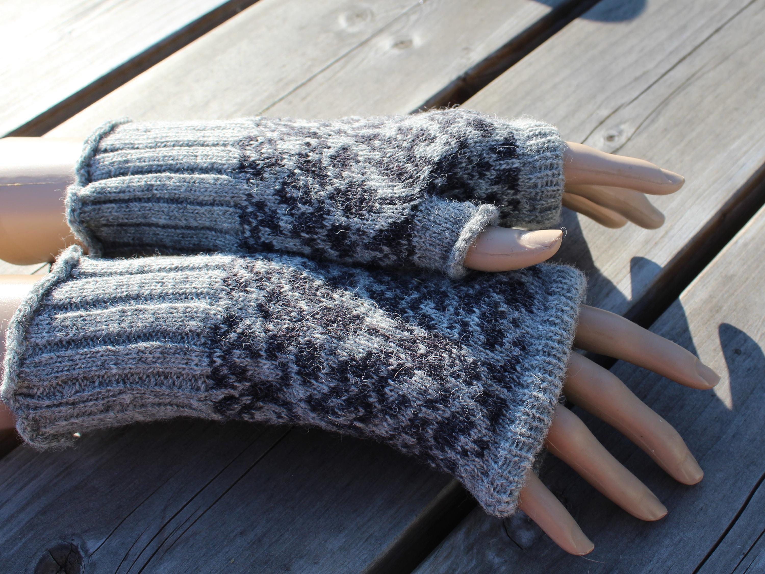 Pair of gray knitted fingerless gloves on a wooden surface