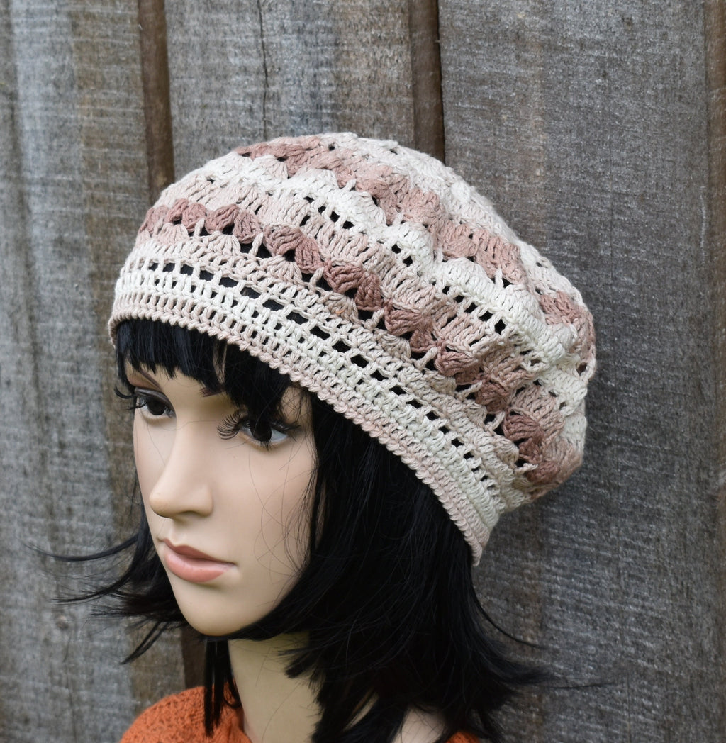 Mannequin head wearing a crocheted beanie with a textured background