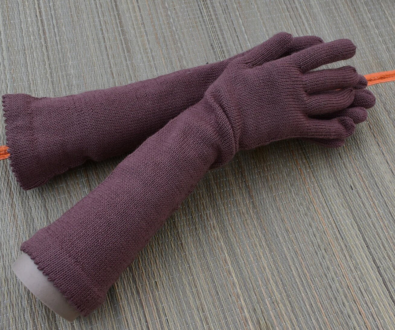 Pair of purple gloves on a textured surface