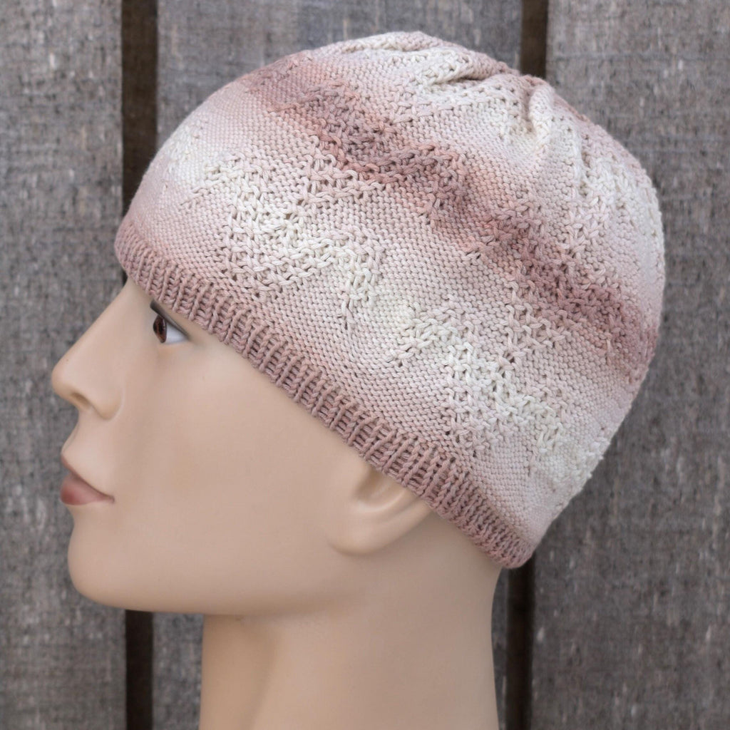 Knitted beige beanie on a mannequin head against a wooden background