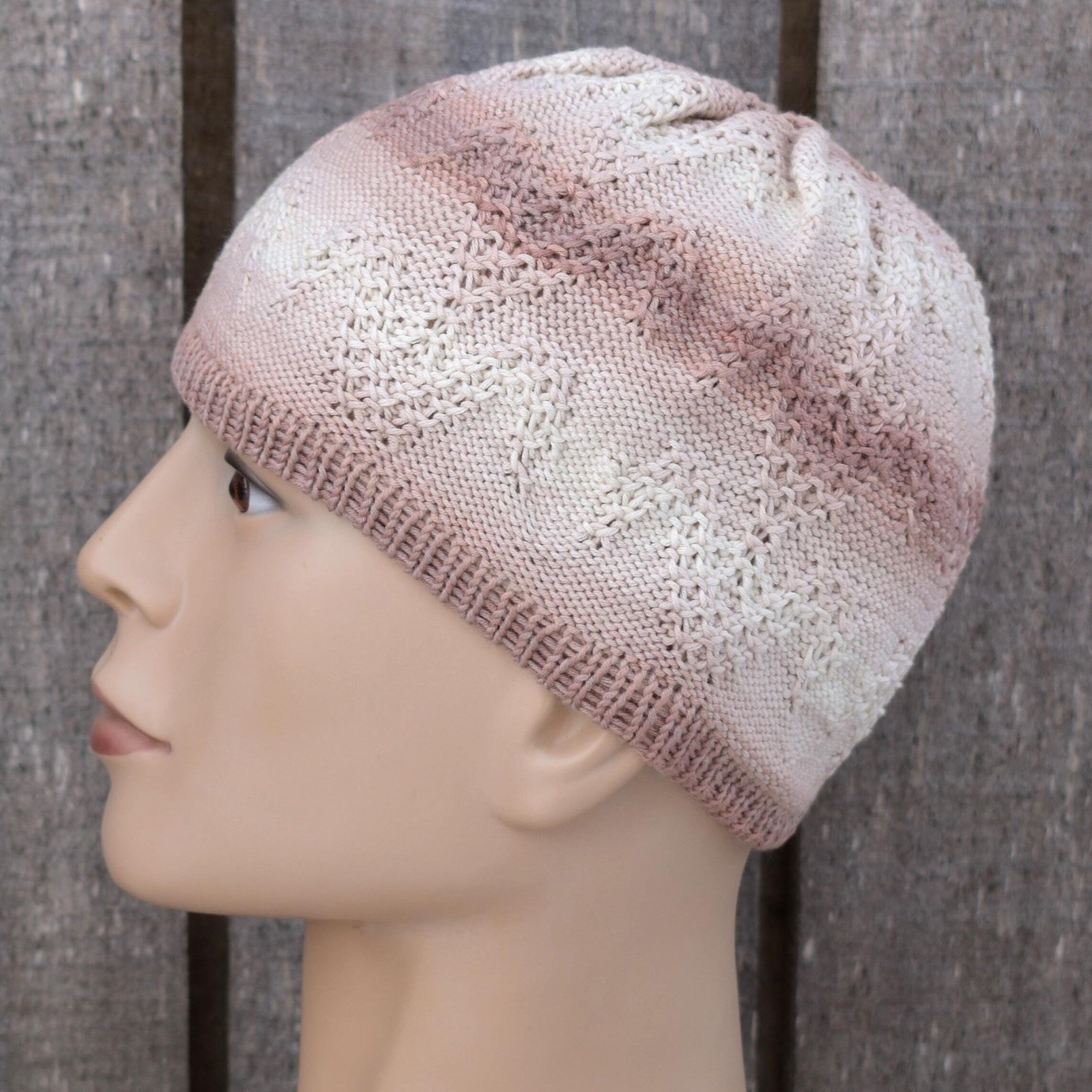 Knitted beige beanie on a mannequin head against a wooden background