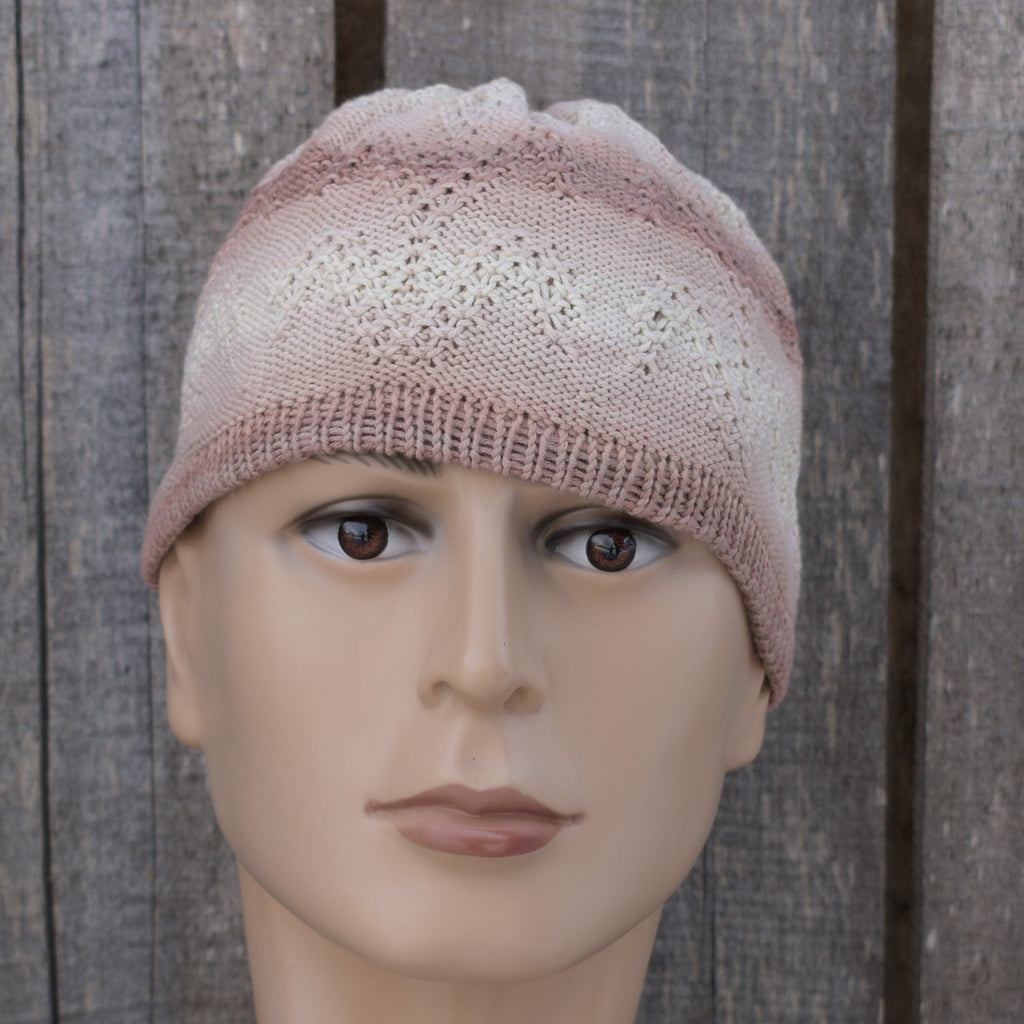 Knitted cotton beanie on a mannequin head against a wooden background