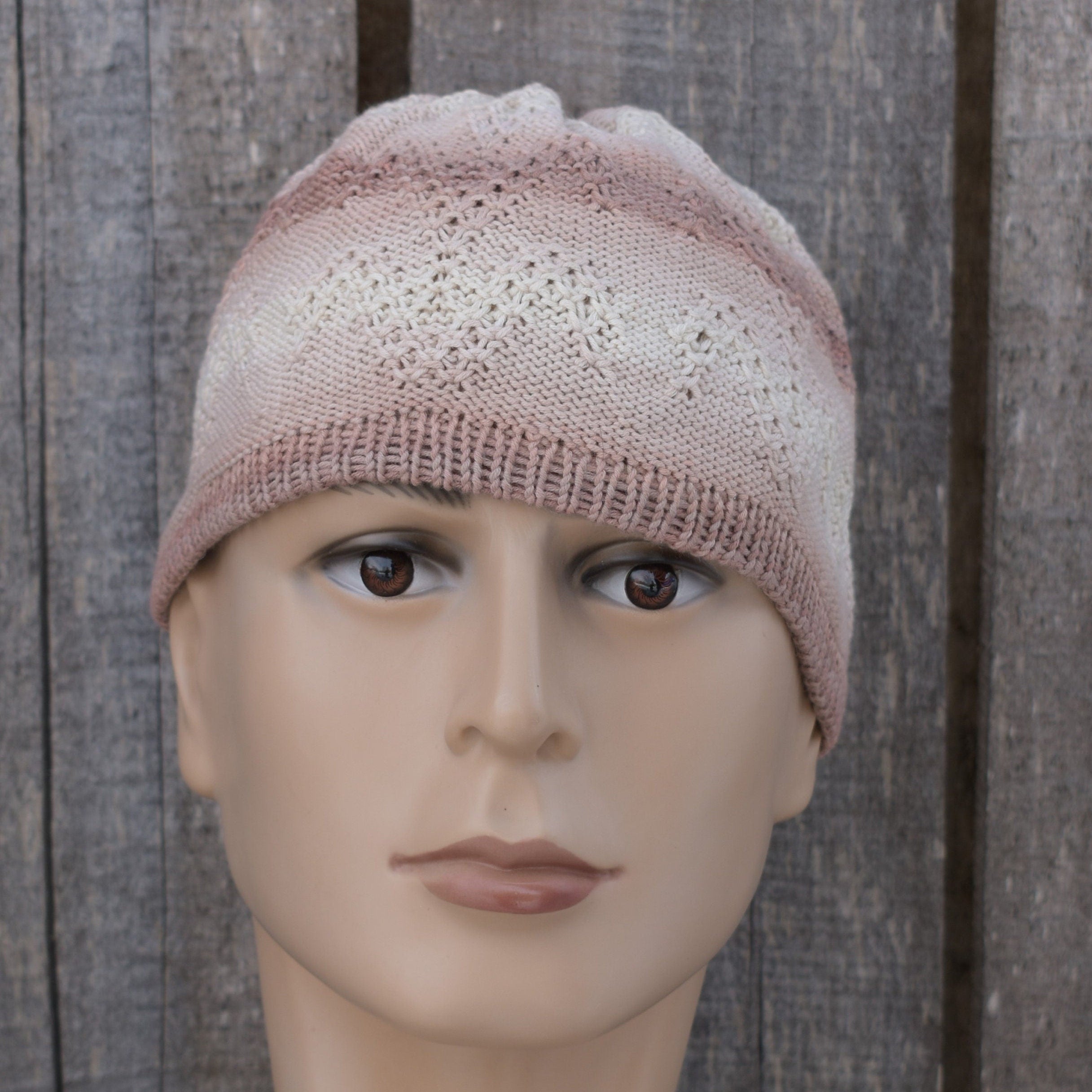 Knitted cotton beanie on a mannequin head against a wooden background